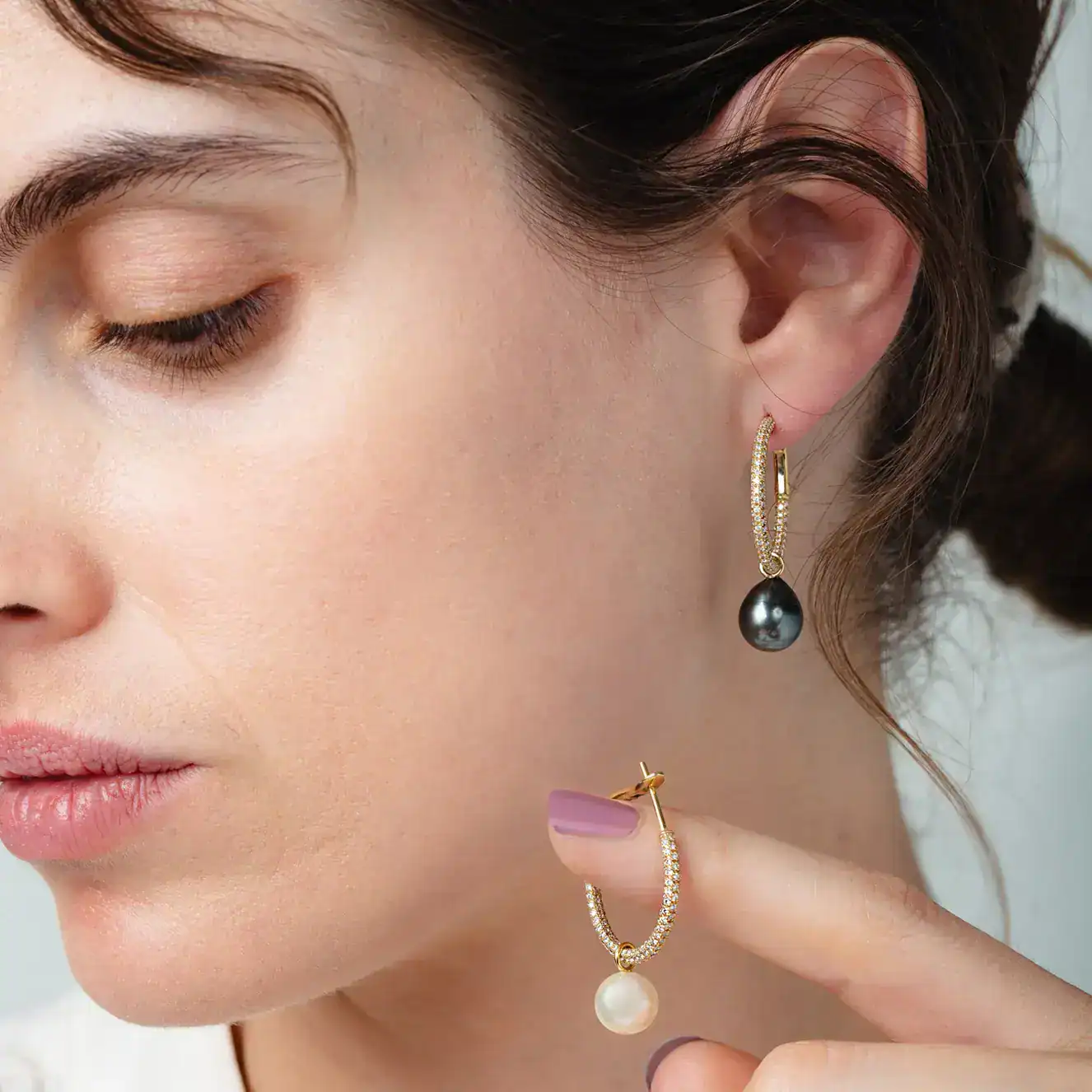 Woman wearing gold hoop earrings with pearl drops